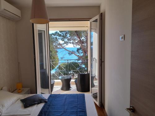 a bedroom with a bed and a view of the ocean at LuxBeachFront in Petrovac na Moru