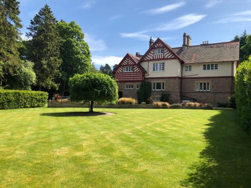 a large house with a large grass yard at Rossal House Apartments, Inverness, Highlands in Inverness