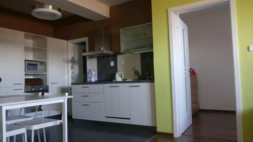 ヴェルカー・ロムニツァにあるApartmán Tatry C3D2の白いキャビネットと緑の壁が備わるキッチン