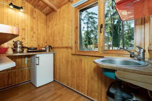 a kitchen with a sink and a window at Domki Letniskowe Kaprys in Pobierowo