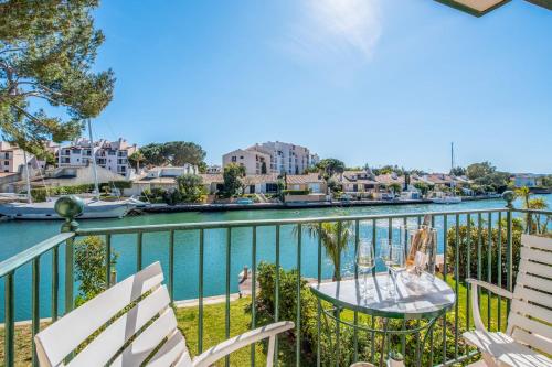 a balcony with chairs and a table next to a river at Appartement Saphir - Welkeys in Grimaud