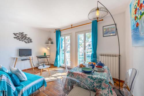 - un salon avec une table et des rideaux bleus dans l'établissement Appartement Saphir - Welkeys, à Grimaud