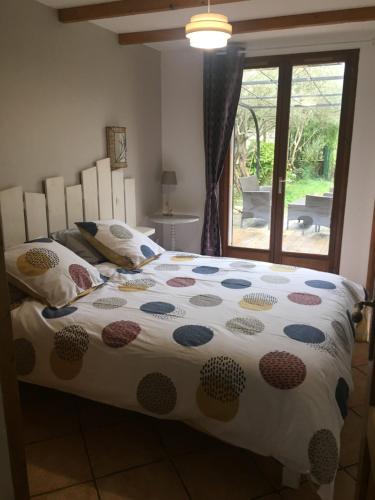 a bedroom with a bed with a polka dot bedspread at Gite des oliviers in La Roque-sur-Cèze