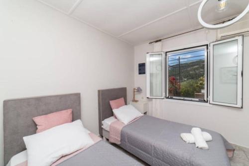 sypialnia z dwoma łóżkami i oknem w obiekcie STATHI'S COTTAGE w mieście Divarata