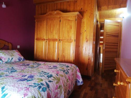 een slaapkamer met een bed en een houten kast bij Dúplex Vallespín in Avila
