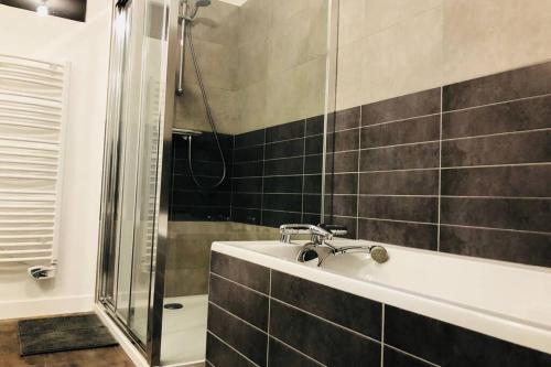 une salle de bain avec un lavabo et une douche dans l'établissement La Vallée Entre dunes et mer, un véritable havre de paix, à Barneville-Carteret