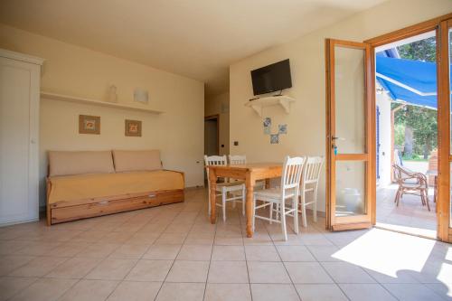 ein Wohnzimmer mit einem Tisch und einem Bett in der Unterkunft Villa le Palme in Capoliveri