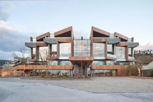 un grand bâtiment avec beaucoup de fenêtres dans l'établissement Bayhill Pool & Villa, à Seogwipo