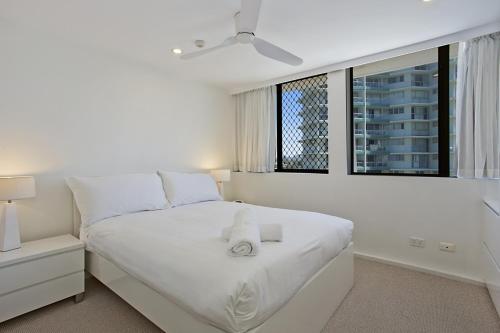 1 dormitorio blanco con 1 cama blanca grande y ventana en Aries Holiday Apartments, en Gold Coast