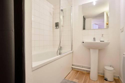 uma casa de banho branca com um lavatório e uma banheira em LocationsTourcoing - Le Loft em Tourcoing