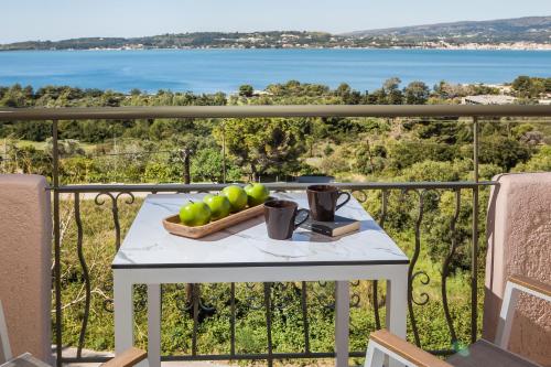 a table with a bowl of fruit on a balcony at Panorama Fanari studios and apartments in Argostoli