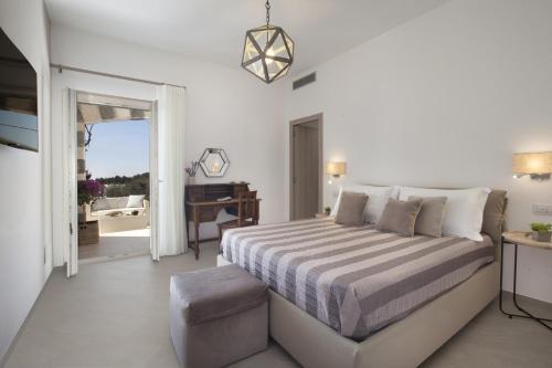 a white bedroom with a bed and a balcony at Amore Rentals - Villa Ligea in SantʼAgata sui Due Golfi