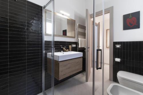 a bathroom with a sink and a glass shower at Amore Rentals - Villa Ligea in SantʼAgata sui Due Golfi