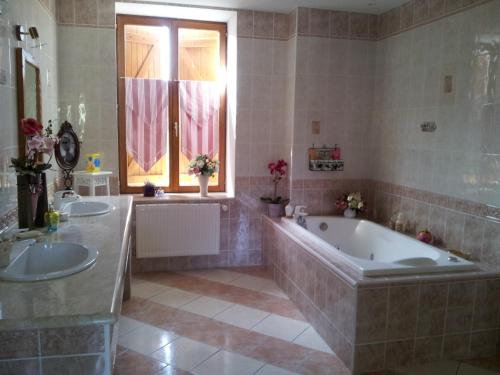 La grande salle de bains est pourvue de 2 lavabos et d'une baignoire. dans l'établissement Villa Sainte Barbe, à Mirecourt