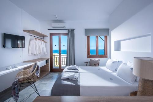 a white bedroom with a large bed and a balcony at Villa Diktynna in Hersonissos