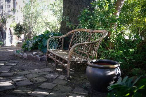 a bench sitting next to a tree and a pot at Le Mas Fraissinet in Saint-Jean-de-Valériscle
