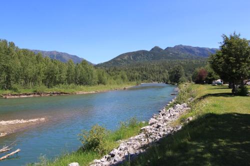 a river with trees and mountains in the background at Pinnacle Ridge Condos by Fernie Central Reservations in Fernie
