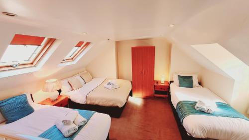 Cette chambre comprend 3 lits et une fenêtre. dans l'établissement Cedar Villa - Perfect For Longer Stays, à Chatham