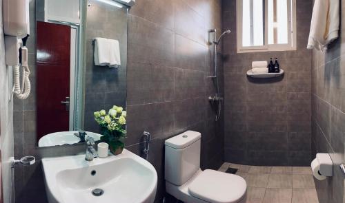 a bathroom with a toilet and a sink at Apex Mbweni Apartment in Kiembi Samaki