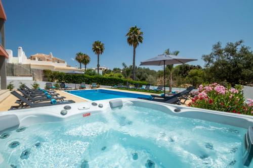 a hot tub in front of a swimming pool at Villa Riviera by Algarve Vacation in Armação de Pêra