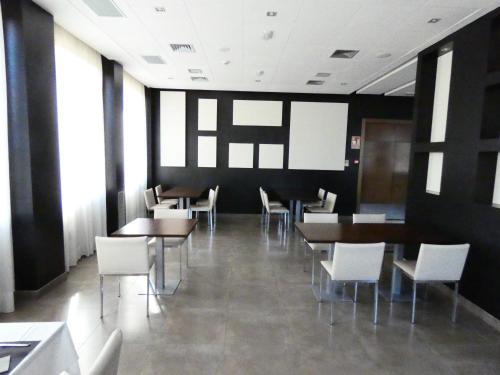 a dining room with tables and white chairs at Fuente del Miro in Valderrobres