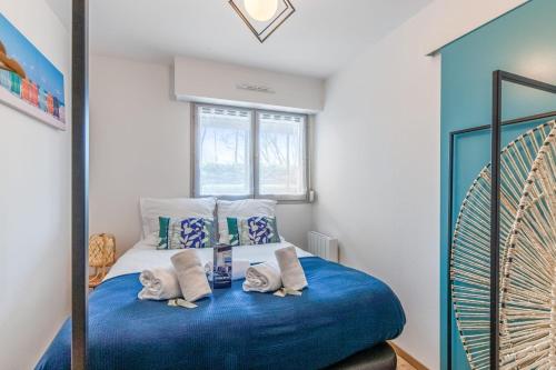 a bedroom with a bed with blue sheets and a window at Nice flat 150m to the beach in Villers-sur-Mer - Welkeys in Villers-sur-Mer