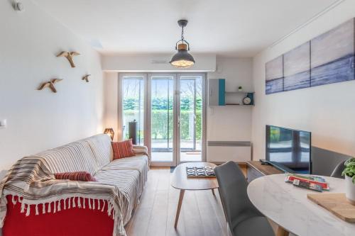 un salon avec un canapé et une table dans l'établissement Appartement Martrois - Welkeys, à Villers-sur-Mer