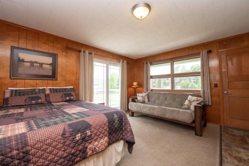 1 dormitorio con 1 cama y 1 sofá en Shore Meadows Lodge LLC, en Lake George