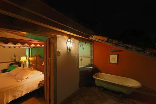 a bathroom with a bed and a bath tub next to a bedroom at Pousada do Amparo in Olinda