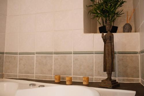 a statue sitting on top of a bathroom sink at Le Mas Fraissinet in Saint-Jean-de-Valériscle
