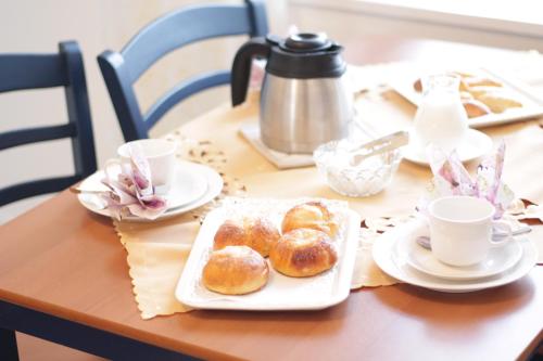 una mesa con una bandeja de donuts y tazas de café en Jokihovi en Nivala