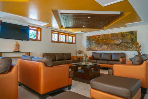 Il comprend un salon avec des canapés et une télévision à écran plat. dans l'établissement Porto das Naus Praia Hotel, à Porto Seguro