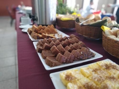 a table with several plates of food on it at Hotel Vila Rica Belém in Belém