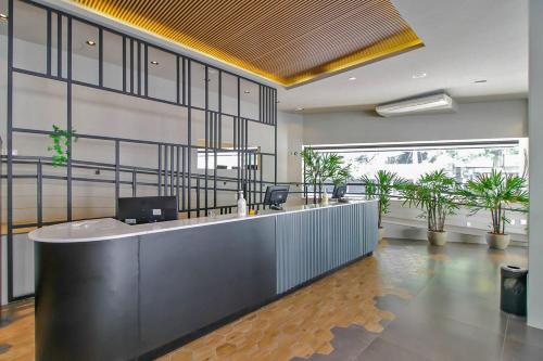 an office with a reception desk and potted plants at Coral Hotel - Próximo a PUCRS in Porto Alegre