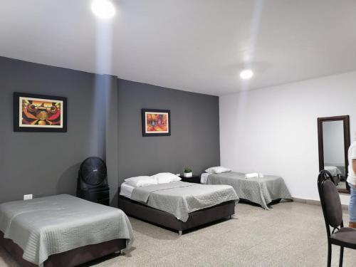 two beds in a room with blue walls at Suite Trujillo in Trujillo