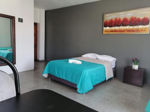 a bedroom with a bed and a painting on the wall at Suite Trujillo in Trujillo