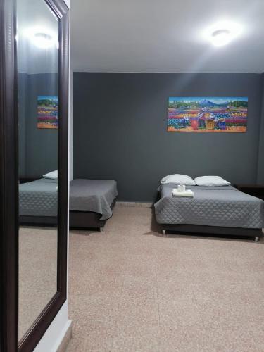 a mirror reflection of a bedroom with two beds at Suite Trujillo in Trujillo