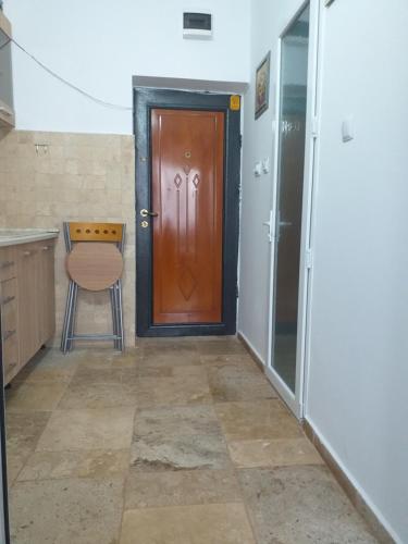 a hallway with a wooden door and a chair at Studio Saturn in Saturn