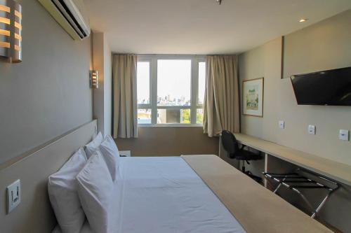 Coral Hotel - Próximo a PUCRS tesisinde bir odada yatak veya yataklar