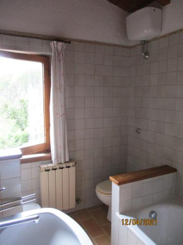 ein Bad mit einem Waschbecken, einem WC und einem Fenster in der Unterkunft Via S Cecilia 30 Urbania in Urbania