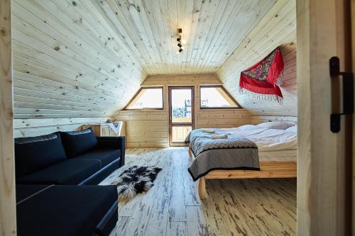 a room with a couch and a bed in a room at Chatka u Górala in Jurgów