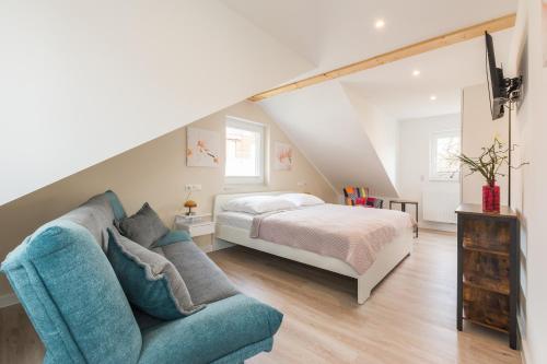 a bedroom with a bed and a blue couch at Naturpark-5 Sterne Ferienhaus-Kamin-Sauna-See in Krakow am See