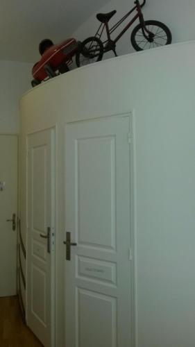 a bike on top of a white door with a bike on top at Hôtel Le Boulevardier in Lyon