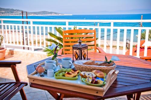 una mesa con una bandeja de comida en la parte superior de un balcón en Hotel Agni On The Beach en Sárti