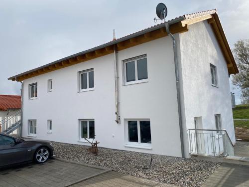a white house with a car parked in front of it at Boardinghouse37 in Schwarzach