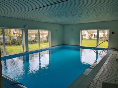a large indoor swimming pool with blue water at Ferienwohnung Appartement Bad Bergzabern mit Schwimmbad und Sauna in Bad Bergzabern