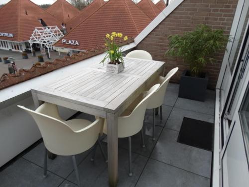 a wooden table and chairs on a balcony with a table at Vakantieappartment Duplex Aquadelta in Bruinisse