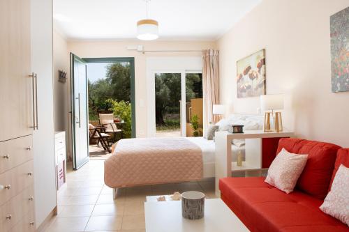 a bedroom with a bed and a red couch at Anelia Studio Lefkada in Lefkada