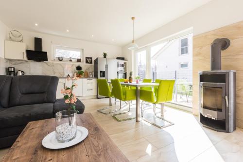 滨湖克拉科Ferienhaus für die ganze Familie - Kamin-Sauna-See的厨房和客厅，配有桌子和黄色椅子