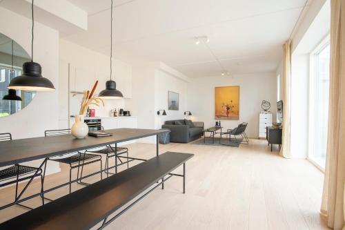 a kitchen and living room with a table and chairs at The Beach Gardens by Daniel&Jacob's in Copenhagen